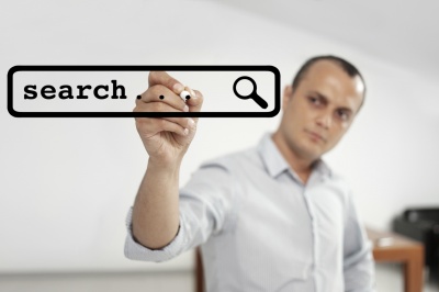 image of man writing search on glass board